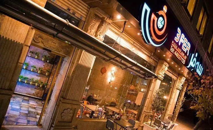 نمای شبانه فست فود سه فر (3FER Pizza and Burger) با تابلوی نئون درخشان، ورودی دکوراتیو و فضای داخلی روشن و دلنشین.