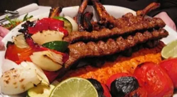 چلوکباب کوبیده و کباب دنده کبابی افق بناب با برنج، سبزیجات کبابی متنوع، گوجه، پیاز، فلفل و لیموترش تازه.