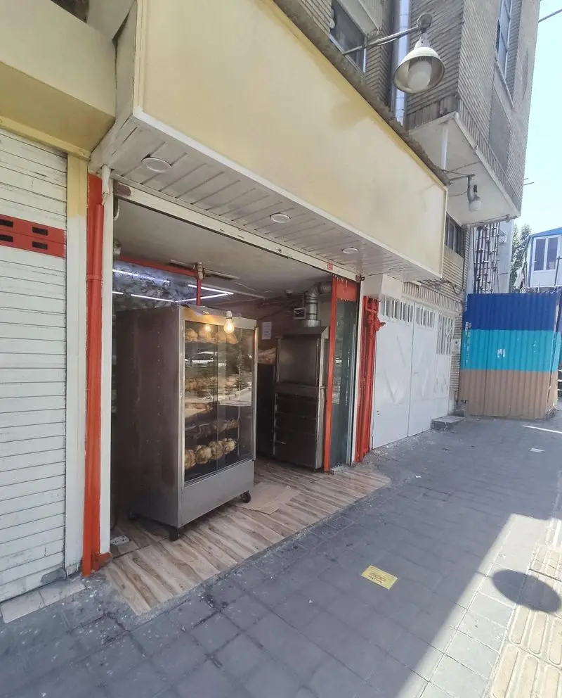 نمای خارجی مغازه مرغ بریان ملاصدرا با دستگاه‌های پخت مرغ‌های طلایی و تازه، آماده سرو به مشتریان.