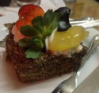 دسر لذیذ و شکلاتی کافه قنادی اوریانت با تزئین توت فرنگی تازه، کرم و میوه‌های رنگارنگ برای تجربه ای شیرین و دلپذیر.