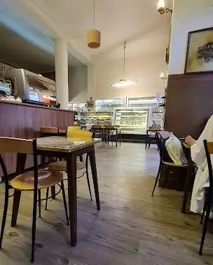 نمایی از فضای دلنشین کافه قنادی اوریانت، شامل پیشخوان مدرن قهوه، ویترین‌های پر از شیرینی و کیک تازه، میز و صندلی‌های چوبی و مشتریان.