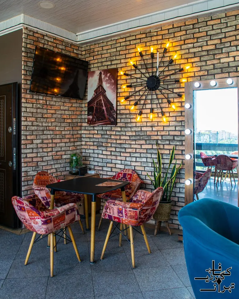 دکوراسیون داخلی کافه یونیس با دیوارهای آجری، میز و صندلی های طرح دار، ساعت نورانی مدرن و آینه هالیوودی. فضایی دلنشین برای مشتریان.