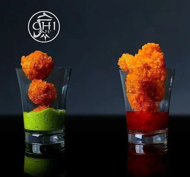 غذاهای خاص و رنگارنگ چی کافه: دو لیوان شات با اسنک‌های نارنجی ترد روی سس سبز و قرمز. تجربه‌ای لذیذ و منحصر به فرد.
