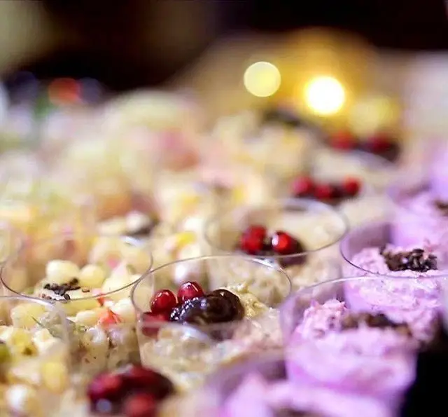 نمایی نزدیک از دسرهای لیوانی و فینگر فودهای متنوع و رنگارنگ چی کافه برای پذیرایی شیک و خوشمزه در رویدادها و کافه.