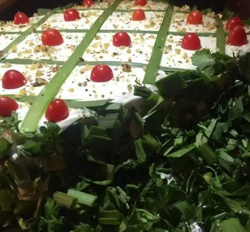 کیک مرغ چی کافه با تزئین گوجه گیلاسی، گردو، نوارهای سبزیجات و اطراف پوشیده از سبزی تازه خرد شده، عالی برای پذیرایی.