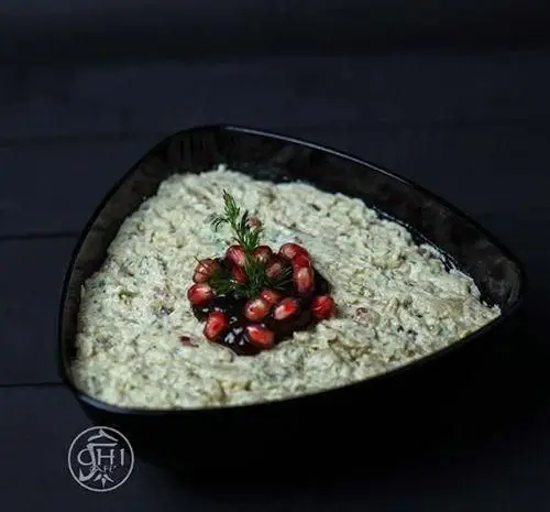 دیپ بادمجان و گردو با تزئین انار و شوید در چی کافه. پیش غذایی لذیذ و سالم برای تجربه طعمی اصیل در کافه.
