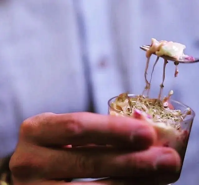 تصویری از یک غذای خاص چی کافه، با سرو جذاب در لیوان کوچک و بافتی کرمی که با چنگال برداشته می‌شود. تجربه‌ای خوشمزه در کافه.