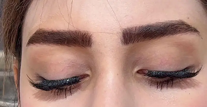 نمای نزدیک از آرایش چشم و ابروی خیره‌کننده در سالن زیبایی کیانا؛ مژه‌های پرپشت و ابروهای طراحی‌شده برای زیبایی بیشتر.