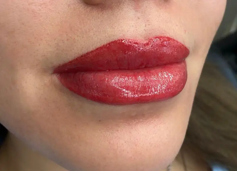 لب‌های زیبا با رژ لب قرمز براق یا شیدینگ لب حرفه‌ای در سالن زیبایی کیانا، ارائه دهنده برترین خدمات آرایش دائم لب و صورت.