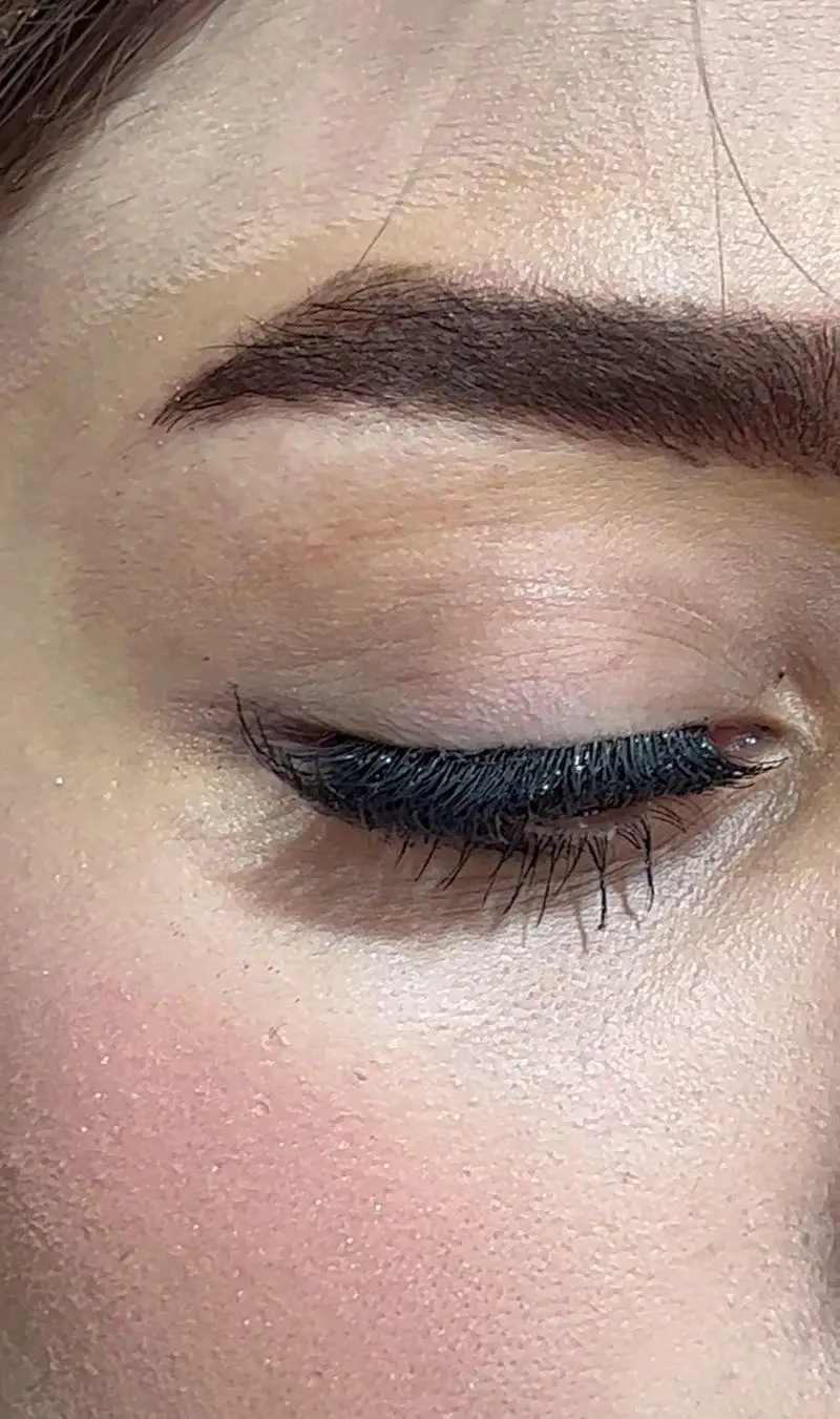 چشم بسته با میکاپ گلیتری مژه و ابروهای طراحی شده در سالن زیبایی کیانا. خدمات تخصصی آرایش و زیبایی چهره.