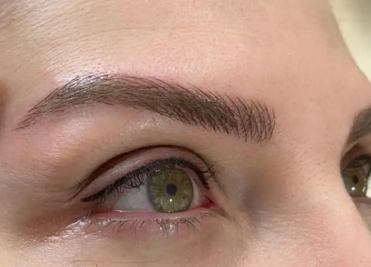 تصویری از ابروهای طبیعی و زیبای مشتری سالن زیبایی کیانا با تکنیک میکروبلیدینگ، همراه با خط چشم دائم یا نیمه‌دائم.