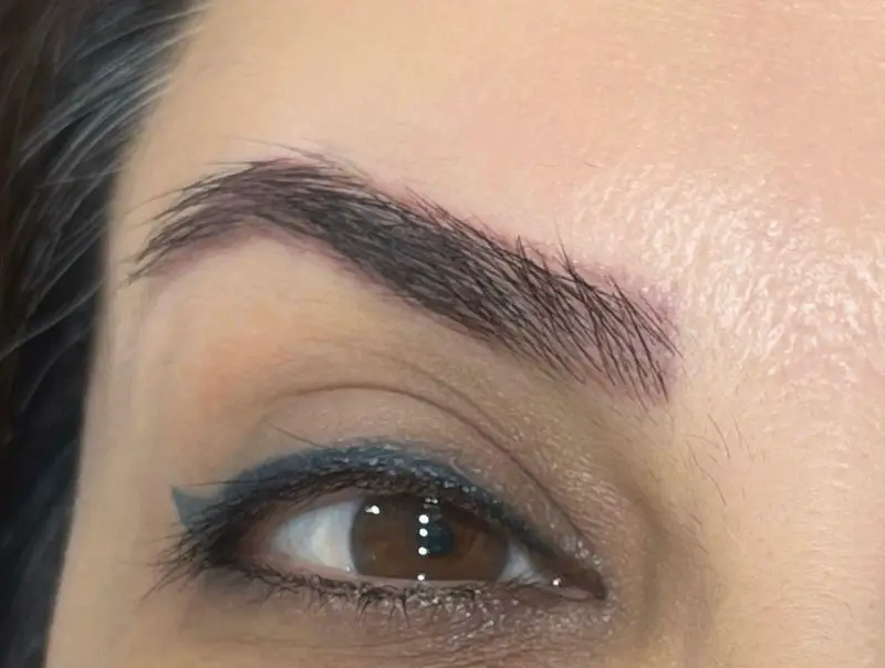 چشم و ابروی مشتری سالن زیبایی کیانا با ابروهای مرتب و طبیعی (میکروبلیدینگ) و آرایش چشم با خط چشم آبی شیک. خدمات زیبایی تخصصی.
