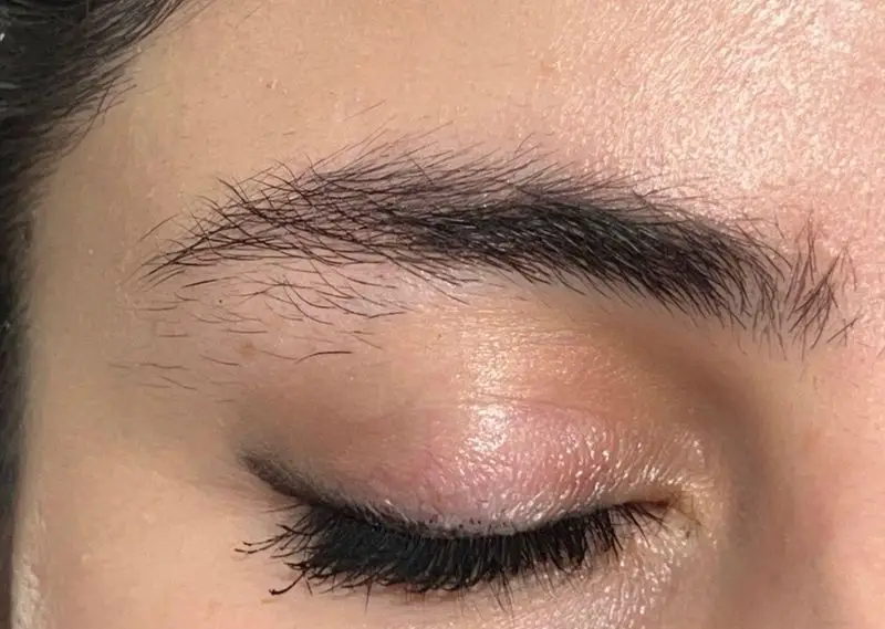 نمای نزدیک چشم با ابروهای طبیعی و مژه‌های پر، آرایش ملایم چشم. خدمات تخصصی اصلاح و قرینه‌سازی ابرو در سالن زیبایی کیانا.