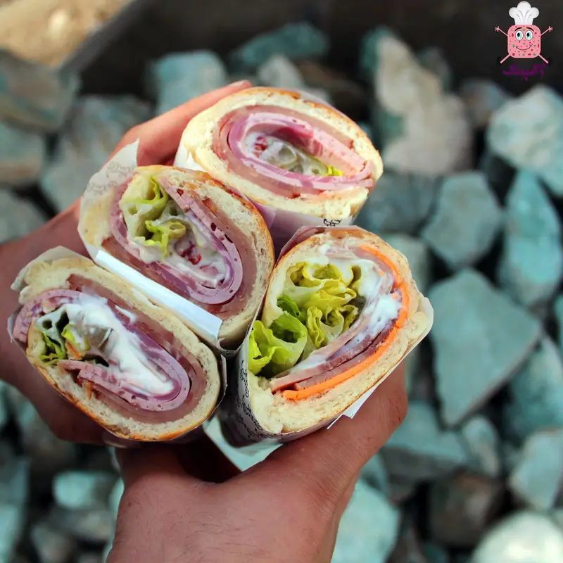 تصویری جذاب از چند ساندویچ باگت ژامبون و کالباس خوشمزه فست فود ژامبونک، پر از گوشت، کاهو و سس، آماده برای تجربه طعم بی‌نظیر.