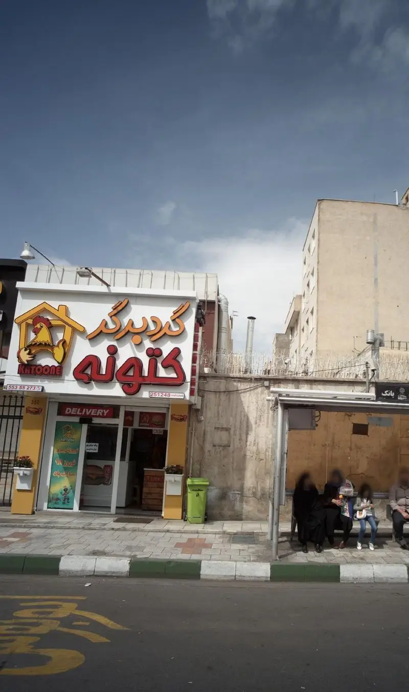 نمای بیرونی فست فود گرد برگر کتونه با تابلوی بزرگ نارنجی و لوگوی مرغ، ارائه دهنده خدمات تحویل با شماره‌های 55355273 و 251248.