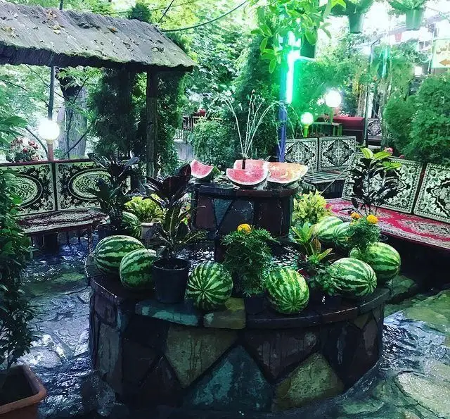 رستوران جویبار: فضای سنتی و سرسبز با آبنما، هندوانه‌های تازه چیده شده، گیاهان زینتی و تخت‌های نشیمن ایرانی برای لحظاتی آرام.