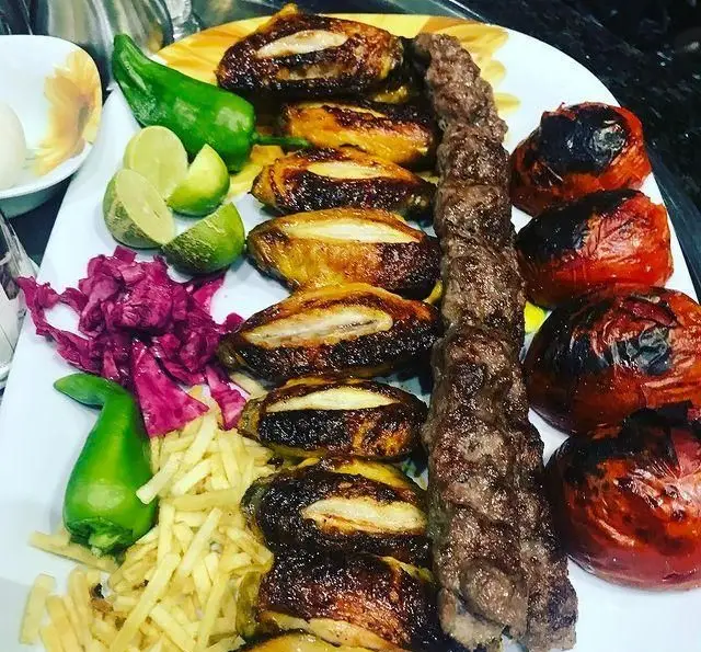 سینی متنوع و خوشمزه کباب کوبیده، جوجه کباب طلایی، گوجه کبابی، سیب‌زمینی سرخ‌کرده و مخلفات در رستوران جویبار.