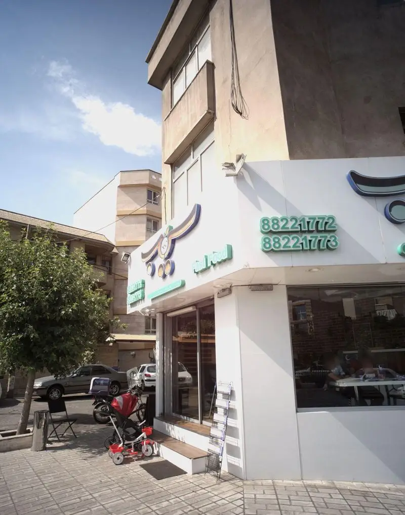 نمای بیرونی فست فود سیب ۳۶۰ با ساختمان، خیابان، اتومبیل، درختان، شماره تماس 88221772 و 88221773 در تهران.