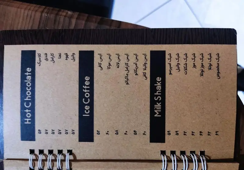 منوی کافه سئول با انواع نوشیدنی‌ها: هات چاکلت، آیس کافی (لاته، موکا، آمریکانو) و میلک شیک‌های (شکلات، موز نوتلا) همراه با قیمت.