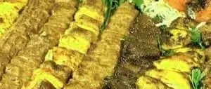 سینی کباب‌های خوشمزه و متنوع کبابی فرد جوان شامل جوجه کباب و کباب کوبیده، یک ضیافت بی‌نظیر برای دوستداران غذای ایرانی.