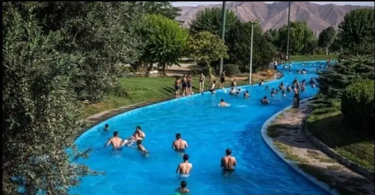 نمایی زیبا از رودخانه آرام پارک آبی آزادگان در یک روز آفتابی تابستان، مکانی عالی برای تفریح و شنا برای خانواده‌ها و جوانان.