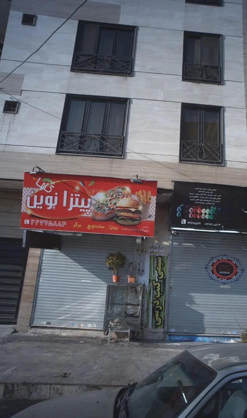 تابلوی بزرگ فست فود پیتزا نوین با تصاویر پیتزا، ساندویچ و برگر در نمای ساختمان شهری، آماده پذیرایی از مشتریان.