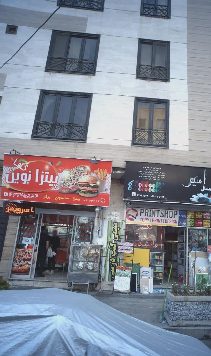 پیتزا نوین: نمای بیرونی فست فود با تابلو قرمز رنگ جذاب حاوی پیتزا، برگر، ساندویچ و سیب زمینی. تجربه طعم عالی.