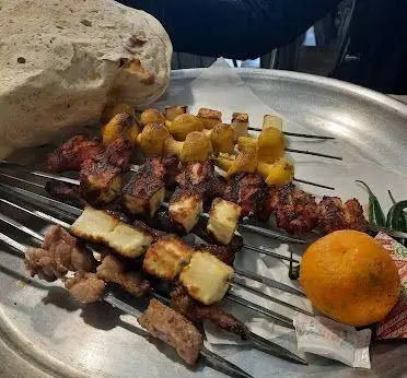 نمای نزدیک از سینی کباب‌های تازه و لذیذ جگر، دل، قلوه، قارچ و پنیر همراه با نان داغ در جگرکی بهارنارنج.