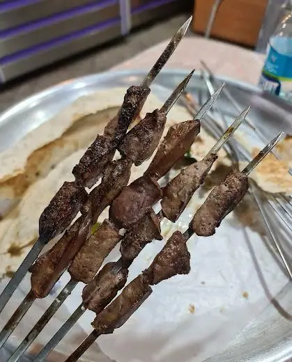 چند سیخ کباب جگر تازه و لذیذ جگرکی بهارنارنج روی سینی با نان داغ. غذایی خوشمزه و سنتی برای دوستداران جگر.