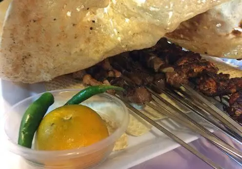 تجربه طعم بی نظیر در جگرکی بهارنارنج: کباب جگر تازه و داغ با نان محلی، فلفل سبز و نارنج برای تکمیل لذت غذای ایرانی.