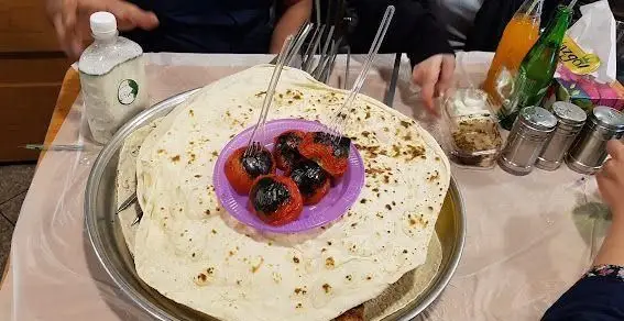 میز شام در جگرکی بهارنارنج با نان داغ، گوجه کبابی، دوغ و نوشیدنی. لذت تجربه کباب و غذای سنتی ایرانی اصیل.