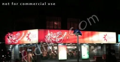 تابلوی روشن فست فود مریانج در شب، با طراحی قرمز و سفید و لوگوی خورشید، نمایانگر محیط دلنشین این رستوران است.