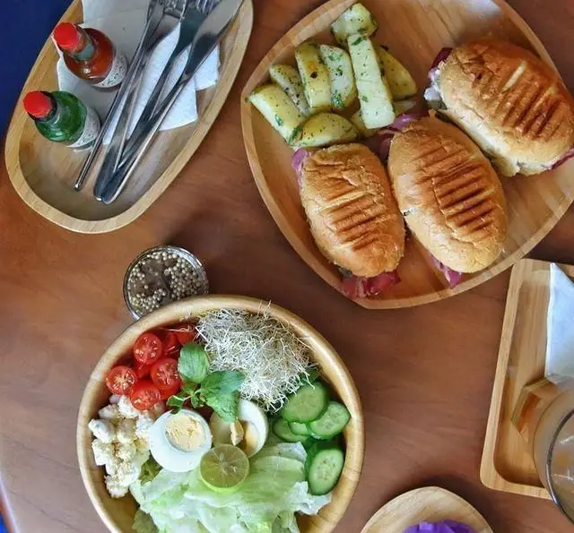 نمایی زیبا از غذای سالم و لذیذ کافه پاییزا: ساندویچ پانینی با سیب زمینی، سالاد تازه با سبزیجات متنوع و تخم مرغ آبپز.