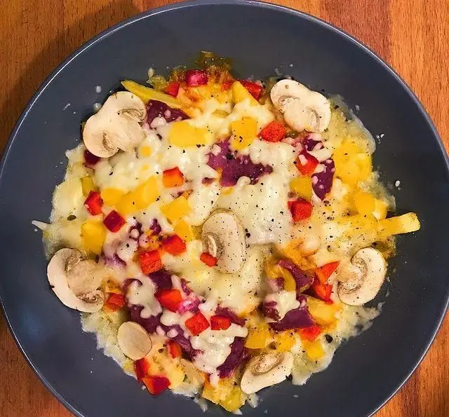 غذای پنیری و رنگارنگ کافه پاییزا شامل قارچ، فلفل دلمه‌ای قرمز و زرد با چاشنی‌های خوشمزه، انتخابی عالی برای دوستداران غذاهای پنیری.