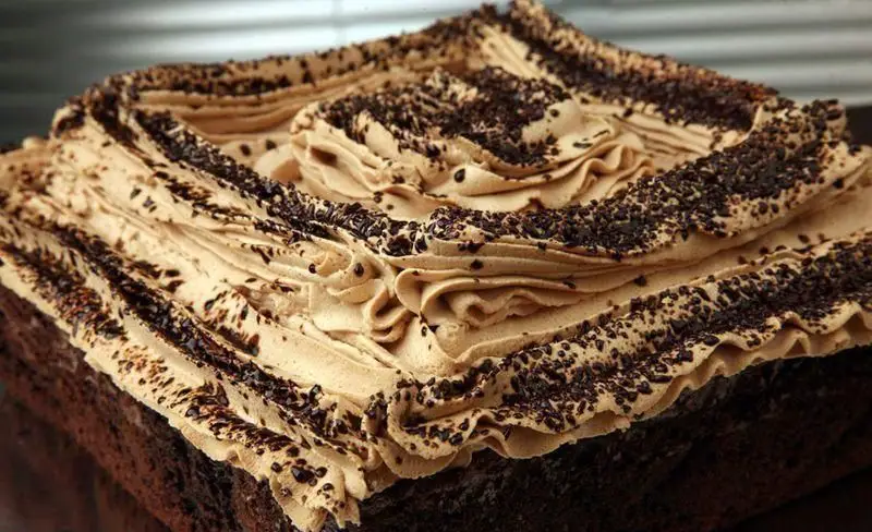 کیک شکلاتی غنی با خامه فرم گرفته قهوه اسپرسو و ترافل شکلاتی، بهترین دسر خاص از خانه کیک پلاتین برای هر جشنی.