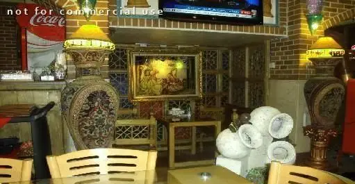 محیط داخلی سفره خانه سنتی پارتیان، مزین به گلدان‌های تزئینی بزرگ، دیوار آجری، مبلمان چوبی و فضایی اصیل و آرامش‌بخش برای تجربه مشتریان