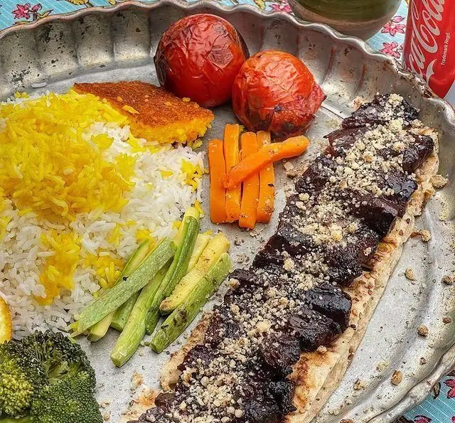 کباب لذیذ گیلانی رستوران گیلار با مغز گردو روی نان، برنج زعفرانی، ته دیگ، گوجه، کدو، هویج و بروکلی. تجربه اصیل طعم شمال.