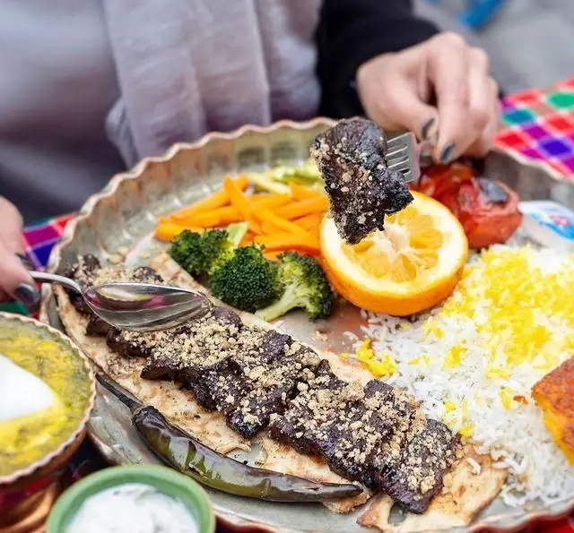 لذت تجربه غذای اصیل گیلانی در رستوران گیلار: کباب با مغز گردو روی نان، برنج زعفرانی، هویج و بروکلی. طعم دلنشین شمال.