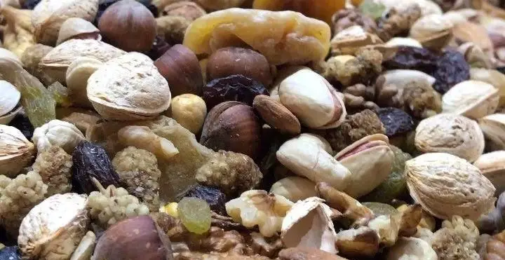 مجموعه‌ای دلپذیر و سالم از آجیل و میوه‌های خشک تازه و باکیفیت کافه قنادی لادن شامل پسته، گردو، فندق، بادام و کشمش.