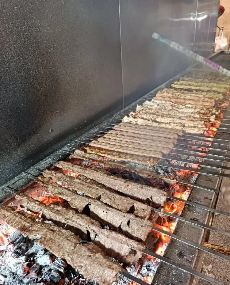 پخت کباب کوبیده ذغالی تازه و لذیذ "تهران کباب" بر روی آتش گداخته. طعم بی‌نظیر غذای اصیل و سنتی ایرانی در رستوران ما.