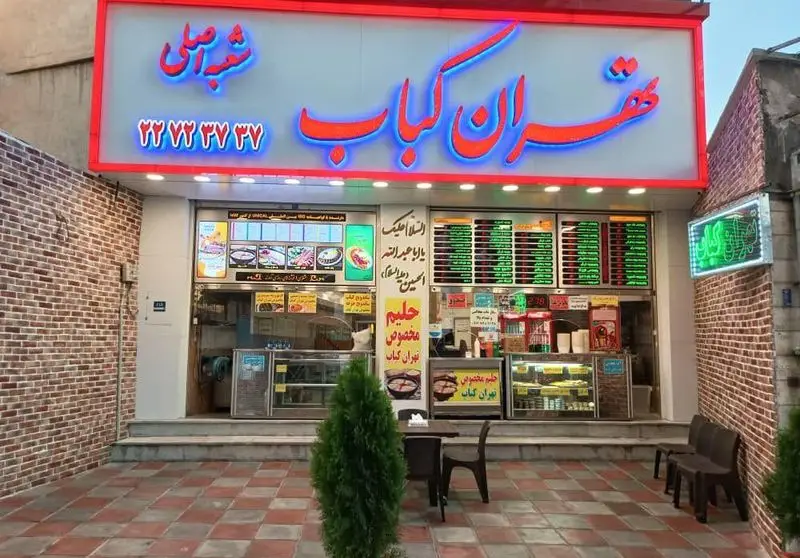رستوران تهران کباب، شعبه اصلی، با تابلوی نئون و ارائه انواع کباب، حلیم مخصوص و غذای ایرانی. شماره تماس نیز روی تابلو.