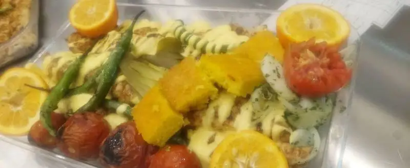 یک ظرف غذای آماده حاوی پاستای رنگی با سس خامه ای، فلفل سبز، گوجه فرنگی کبابی، کدو حلوایی و تکه های پرتقال، انتخابی سالم از تهران کباب.