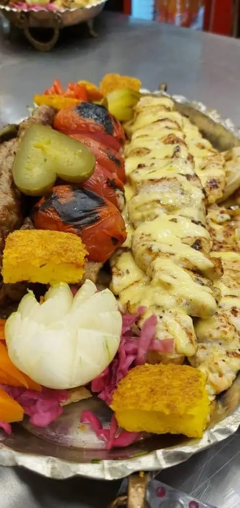 سینی بزرگ کباب مخصوص تهران کباب شامل جوجه کباب با سس پنیر، کباب گوشت، گوجه کبابی، خیارشور، پیاز و ته دیگ. غذای خوشمزه.