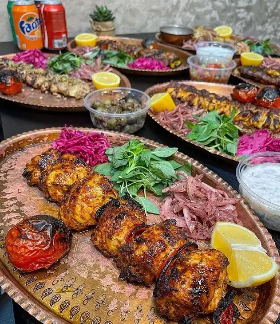 انواع کباب ایرانی شامل جوجه کباب و کوبیده در رستوران مزه کباب گیشا با مخلفات تازه و خوش‌طعم آماده سرو.