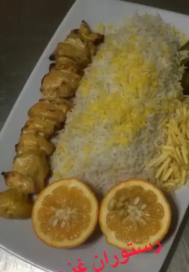 جوجه کباب زعفرانی با برنج اعلا، خلال سیب زمینی، پرتقال و مخلفات. غذایی لذیذ از رستوران غنچه برای تجربه طعم بی‌نظیر.