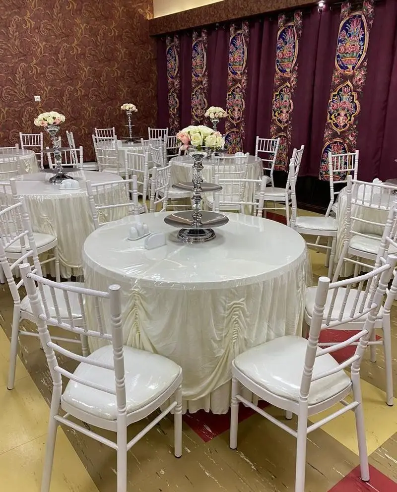 تجهیزات و ظروف کرایه ستاره: چیدمان شیک میز و صندلی سفید برای مراسم، با رومیزی‌های زیبا و ظروف پذیرایی جهت اجاره.