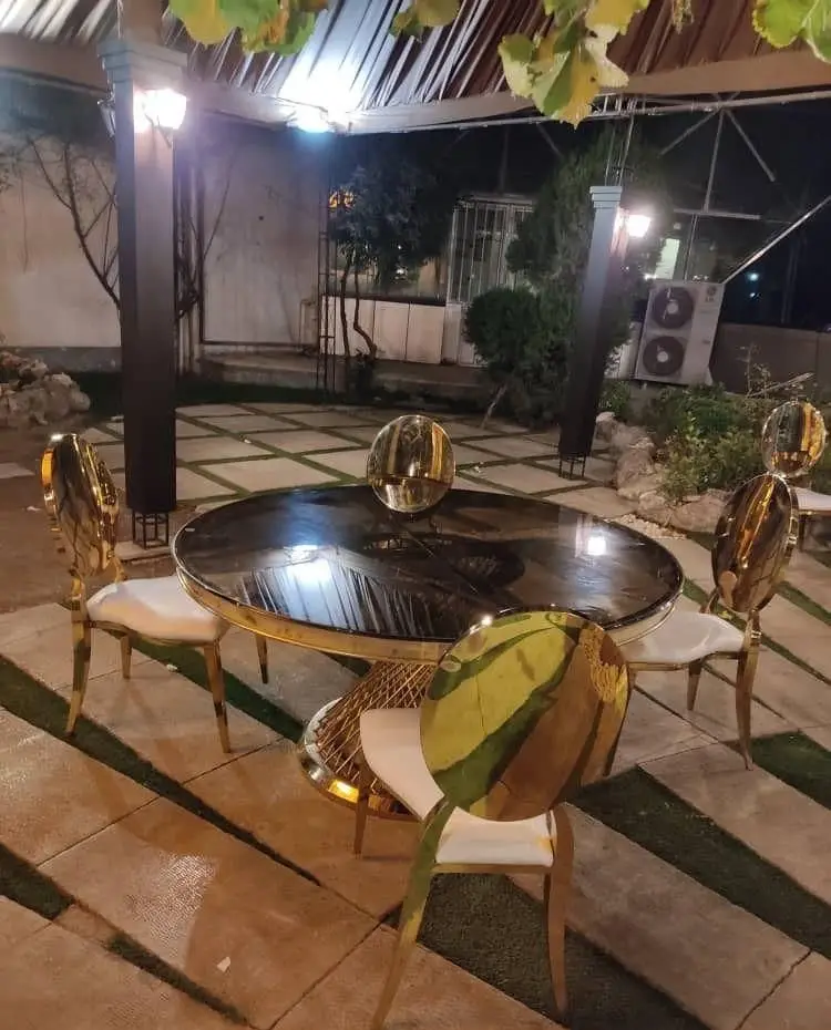 میز و صندلی‌های لوکس طلایی مدرن کرایه ای در فضای باز شب. ایده‌آل برای تجهیزات تشریفات و مراسم خاص ستاره.