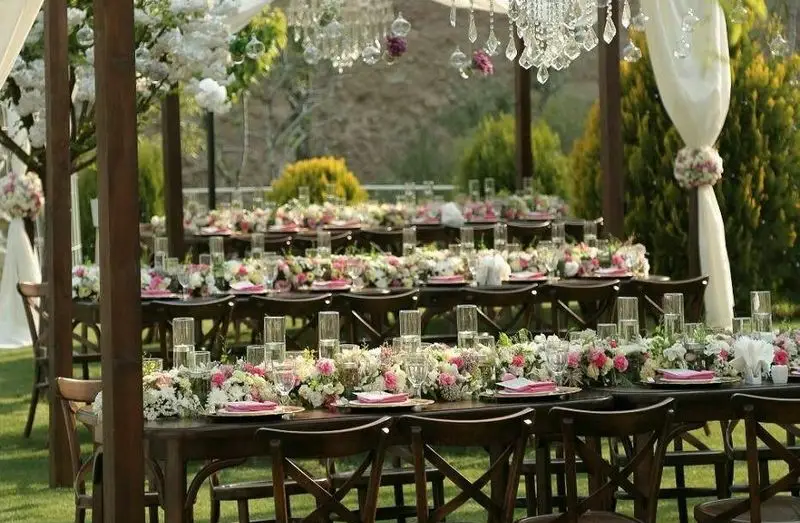 تجهیزات کرایه ستاره: دکوراسیون مجلل و بی‌نظیر مراسم عروسی در فضای باز، شامل میز و صندلی چوبی، گل‌آرایی خاص و ظروف کرایه لوکس.