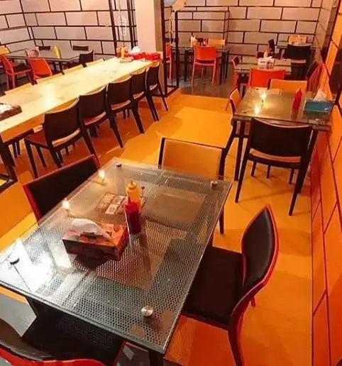 محیط داخلی زیبا و مدرن فست فود بشکه، دارای میزهای چوبی بلند و شیشه‌ای، صندلی‌های راحت و دکوراسیون منحصر به فرد.