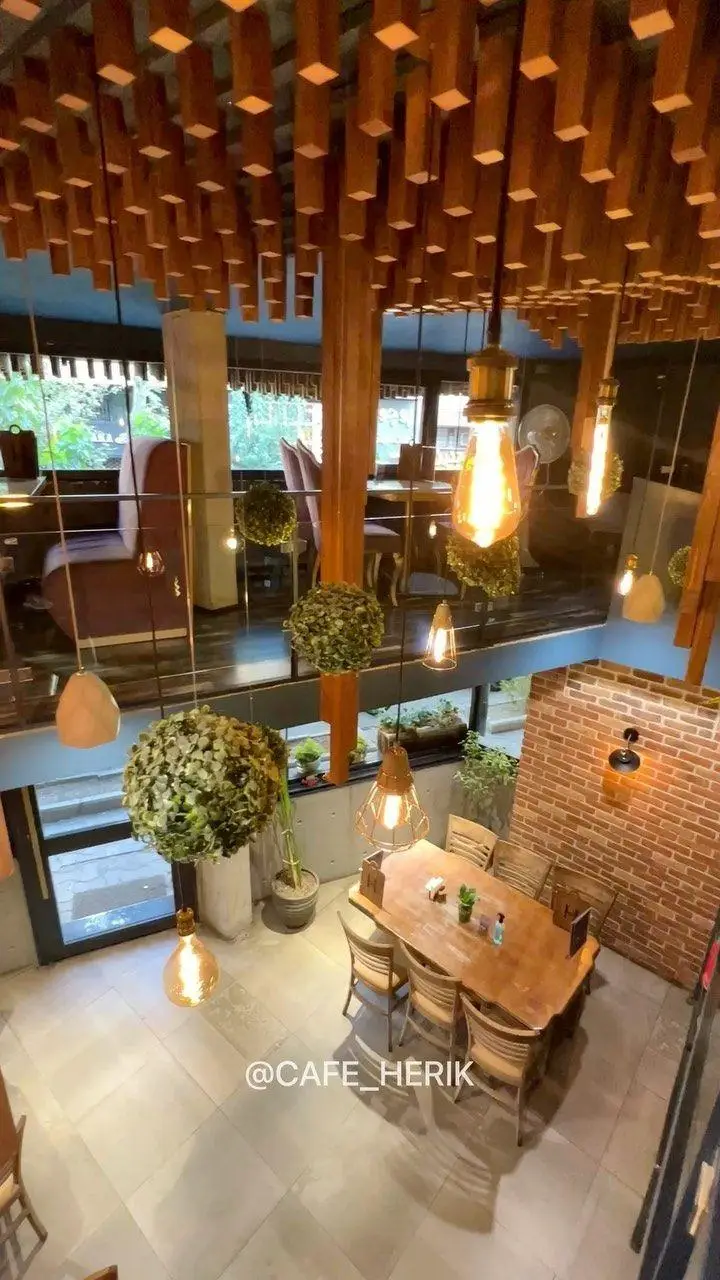فضای داخلی دلنشین کافه رستوران هریک با سقف چوبی خاص، نورپردازی گرم و دکوراسیون مدرن چند طبقه برای تجربه‌ای بیادماندنی.